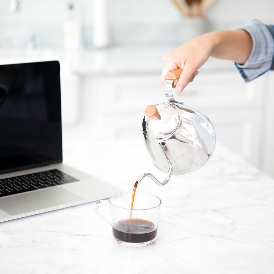 a woman is pouring from a coffeepot, taking time to relax