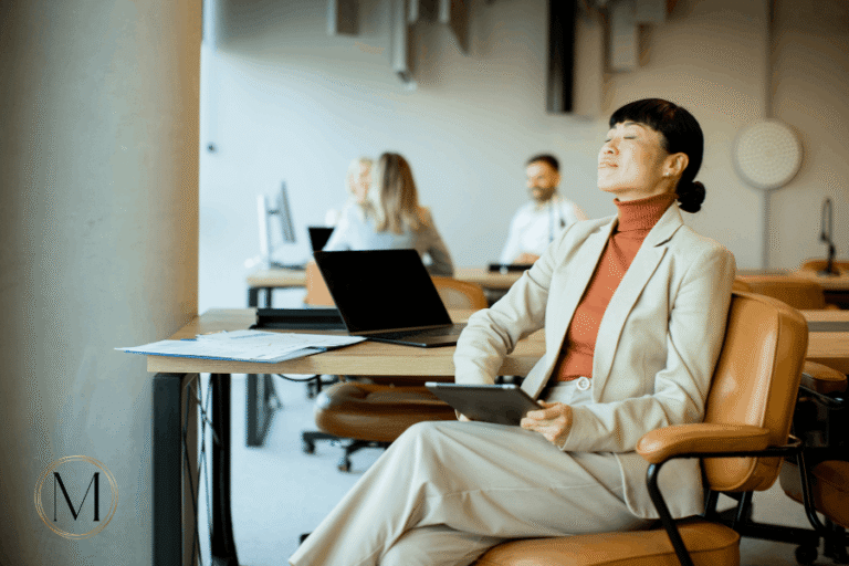 perimenopause and work: woman pausing at her desk during a tiring workday
