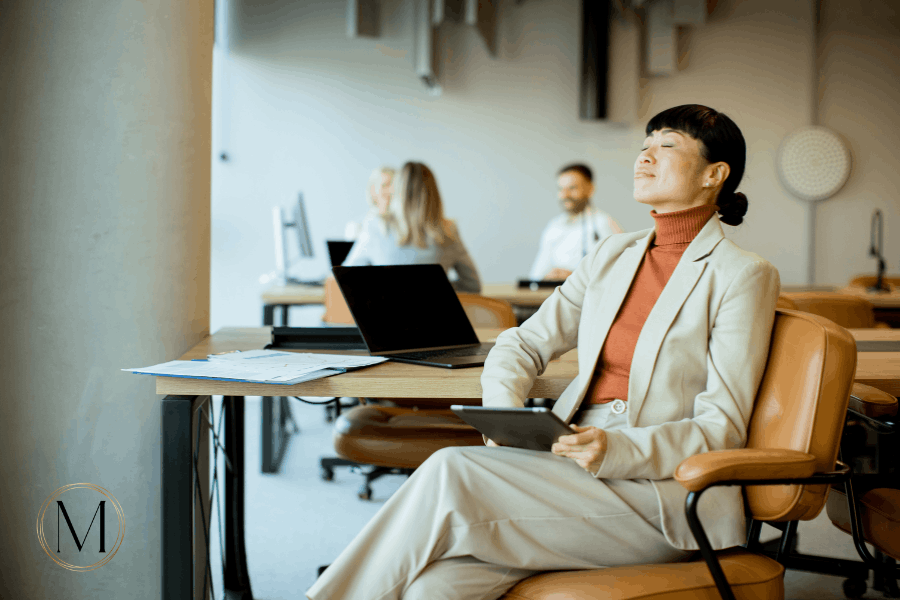 perimenopause and work: woman pausing at her desk during a tiring workday